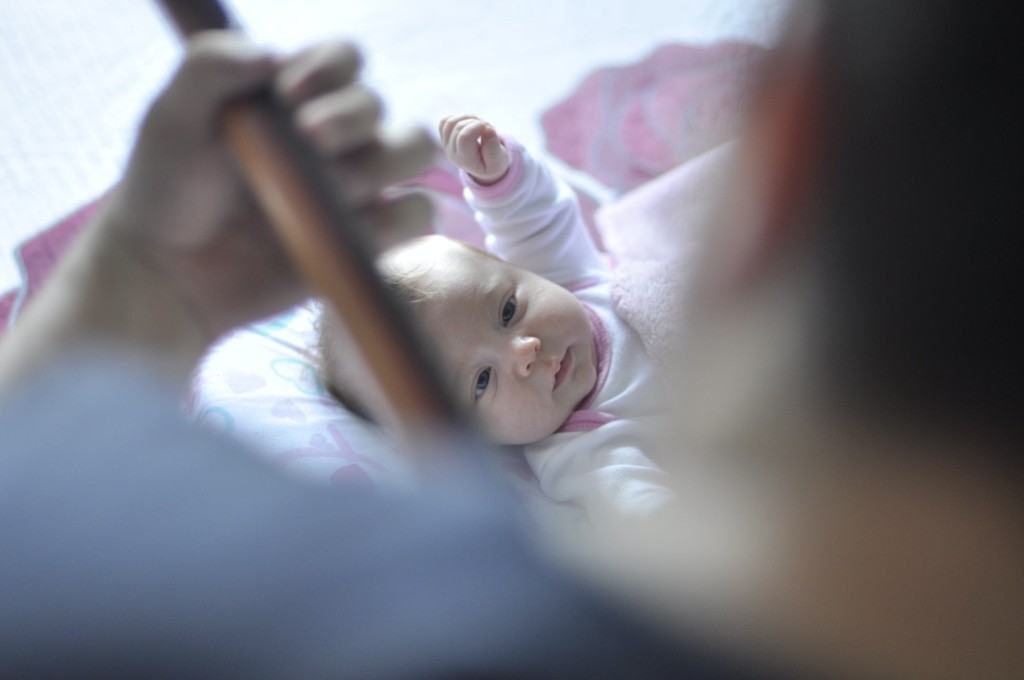 Ein Baby hört und schaut aufmerksam einem Gitarrenspieler zu